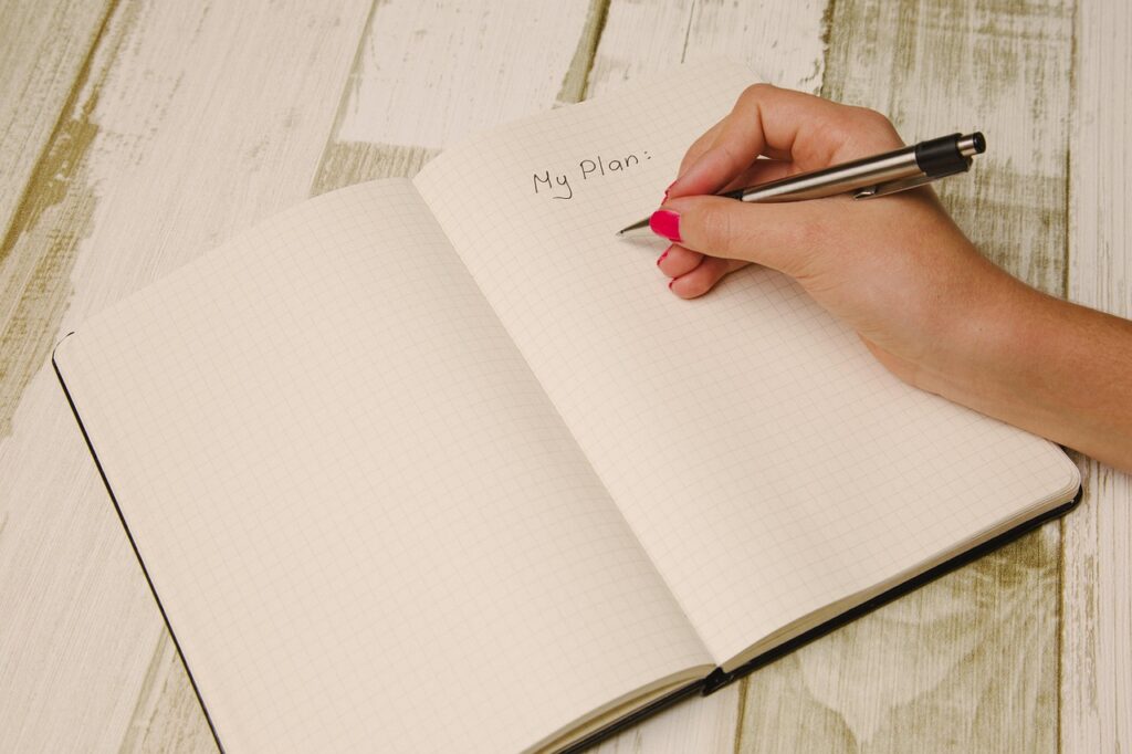 Hand making notes in an open planner