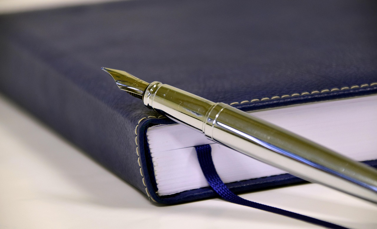 Fountain pen resting on a closed notebook