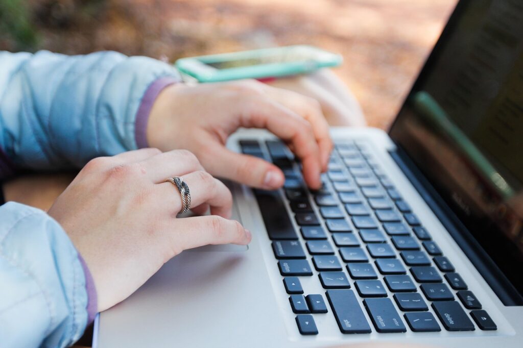Hands using a laptop keyboard